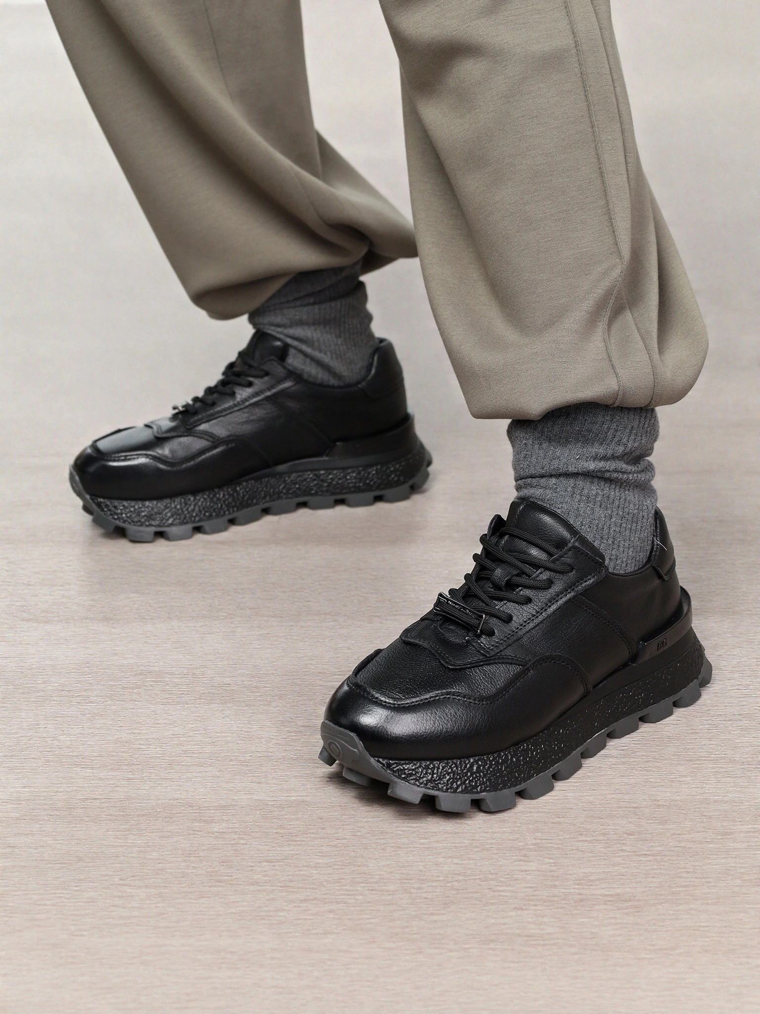 Кроссовки черного цвета с пряжкой на рельефной подошве 